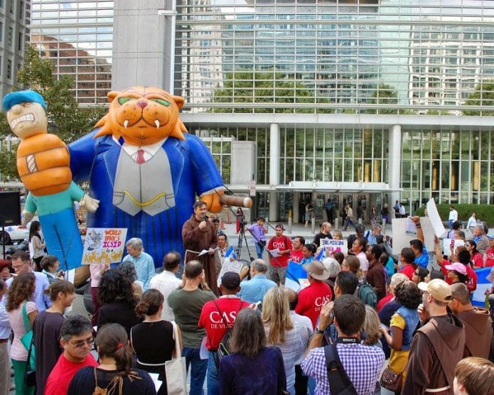 Proud of supports listening to a speaking during a World Bank Protest