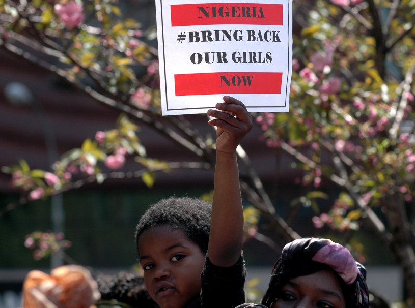 Boy holds sign to bring our girls back at rally