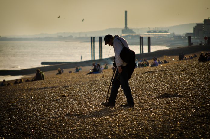 man walks along beach in destination town