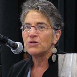 Phyllis Bennis speaking at a microphone.