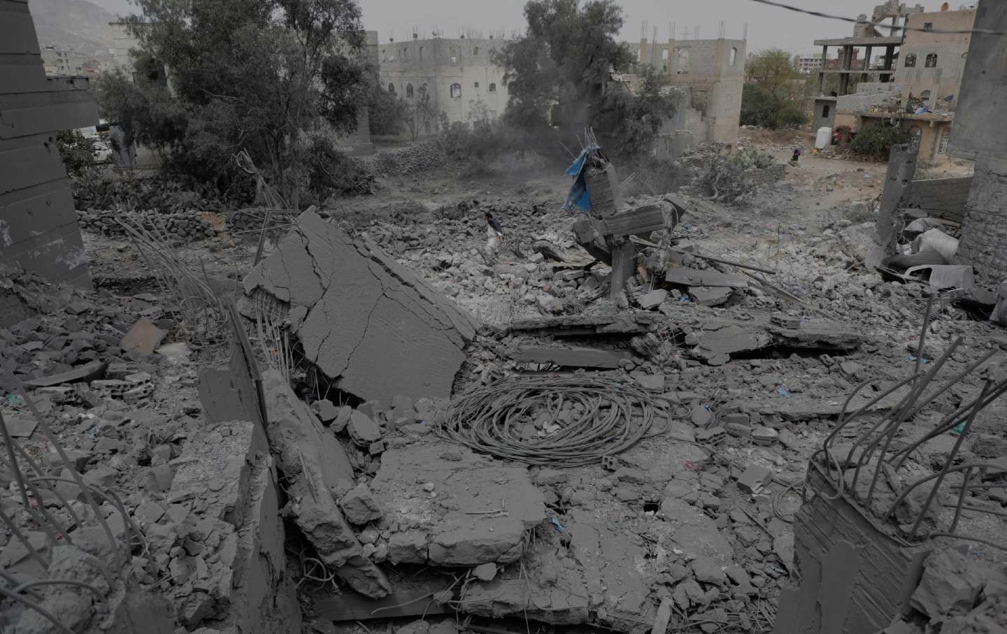 A Yemeni walks over the debris of a destroyed building after it was struck by US air strikes in Sanaa, Yemen, Monday, March 24, 2025.