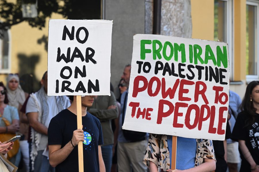 Various signs protesting the U.S. war against Iran