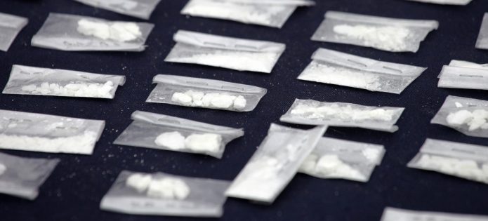 Seized cocaine in little baggies spread across a table.