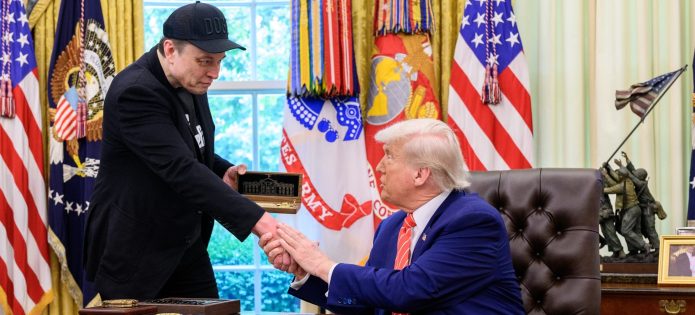 Elon Musk, wearing a DOGE hat, shakes hands with Donald Trump in the Oval Office. (Shutterstock)